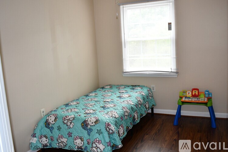 A Hello Kitty bedroom with a bed and a small blue stool.