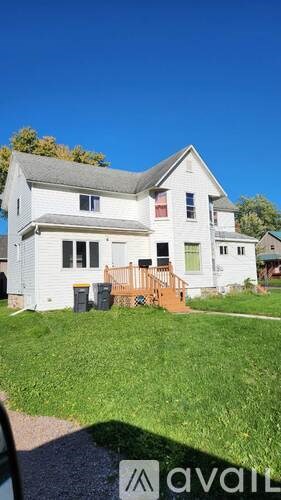 A house with a white exterior and a grey roof is for sale.