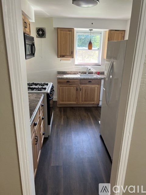 A kitchen with wooden cabinets and a window.