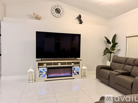 A living room with a television and a fireplace.