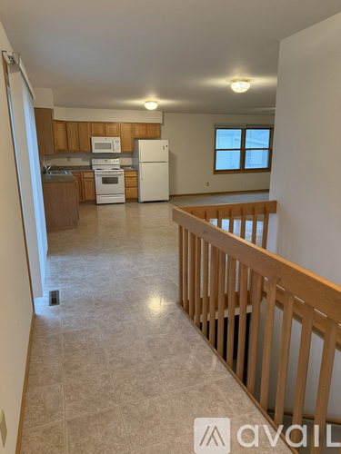 A kitchen with white appliances and wooden cabinets.