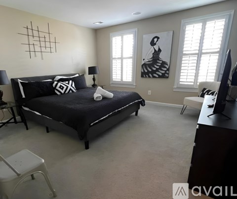 A bedroom with a large bed and a painting on the wall.
