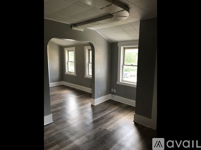 A room with wooden floors and two windows.