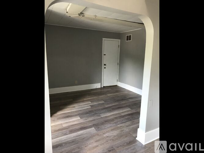 A room with a wooden floor and a white door.