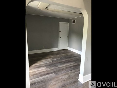 A room with a wooden floor and a white door.