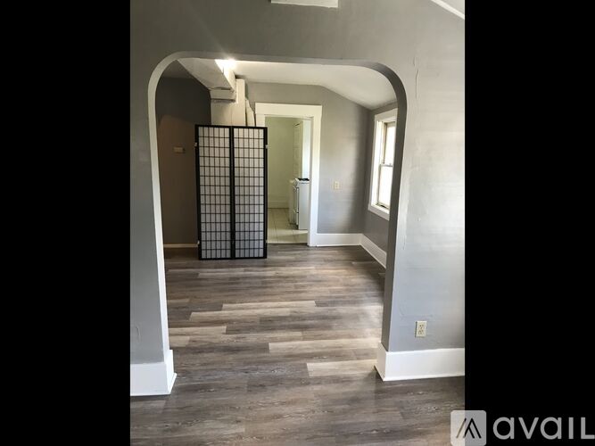 A hallway with a gate in the middle and a wooden floor.