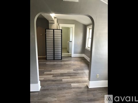 A hallway with a gate in the middle and a wooden floor.
