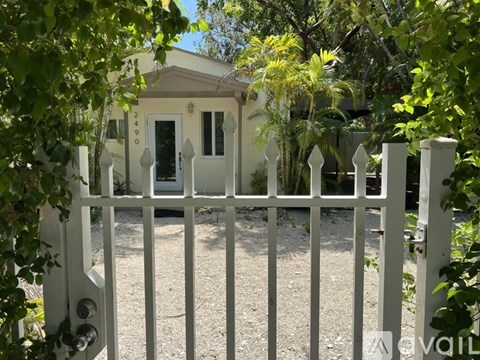 A white house with a white gate and a number 2403 on the front door.