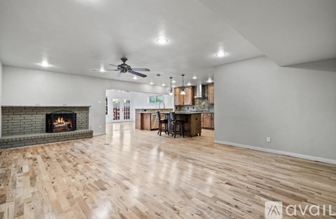 A spacious living room with a fireplace and hardwood floors.