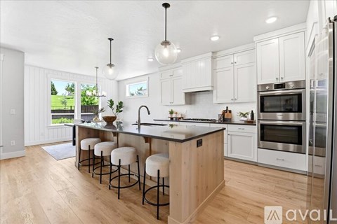 A kitchen with white cabinets and a wooden island.