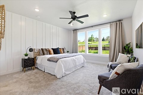 A bedroom with a large bed and a ceiling fan.