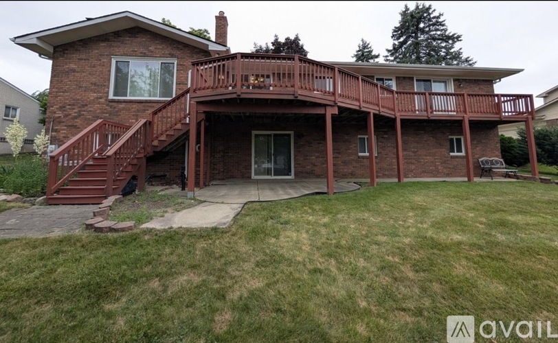 A house with a red brick exterior and a large deck.