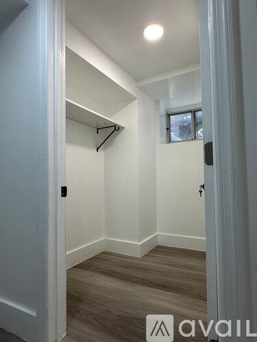A hallway with a coat rack and a window.