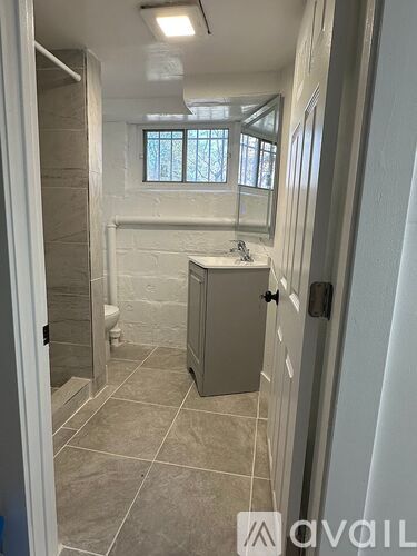 A bathroom with a sink, mirror, and a window.