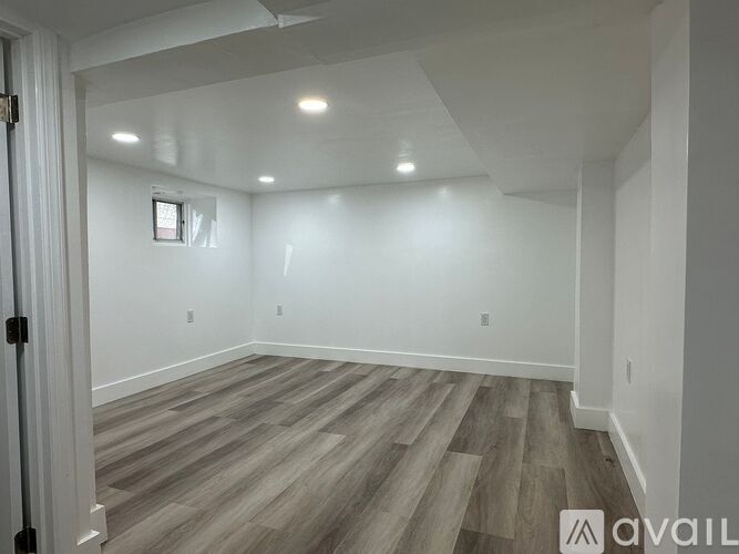A room with wooden flooring and white walls.