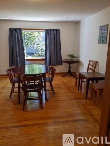 A dining room with a table surrounded by chairs.