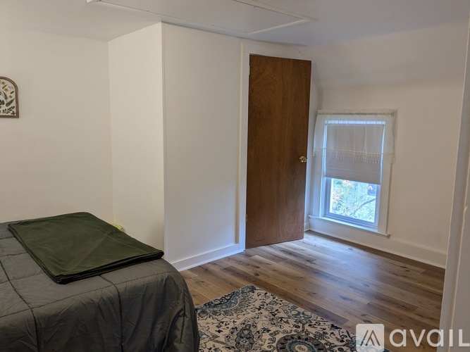 A bedroom with a bed and a window.