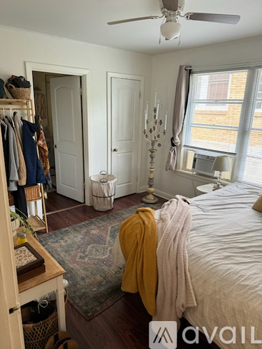 A bedroom with a bed, a dresser, a window, and a ceiling fan.