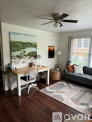 A room with a desk and a painting on the wall.