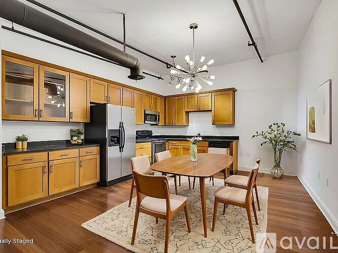 A kitchen with wooden cabinets and a black refrigerator.