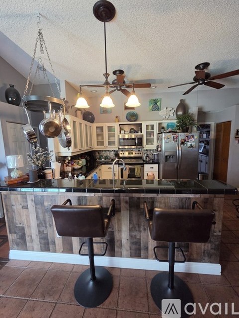 A kitchen with a bar counter and two stools.