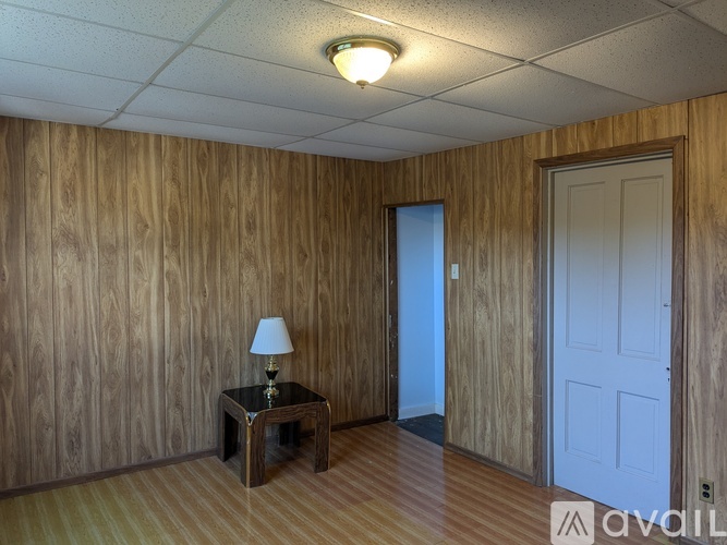 A room with wooden walls and a lamp on a table.