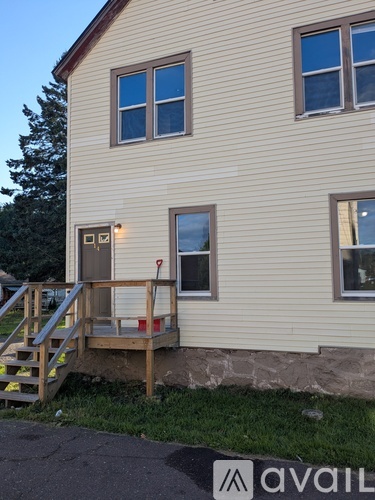 A house with a wooden deck and a stone wall.