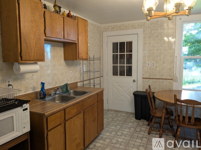 A kitchen with wooden cabinets and a white microwave.
