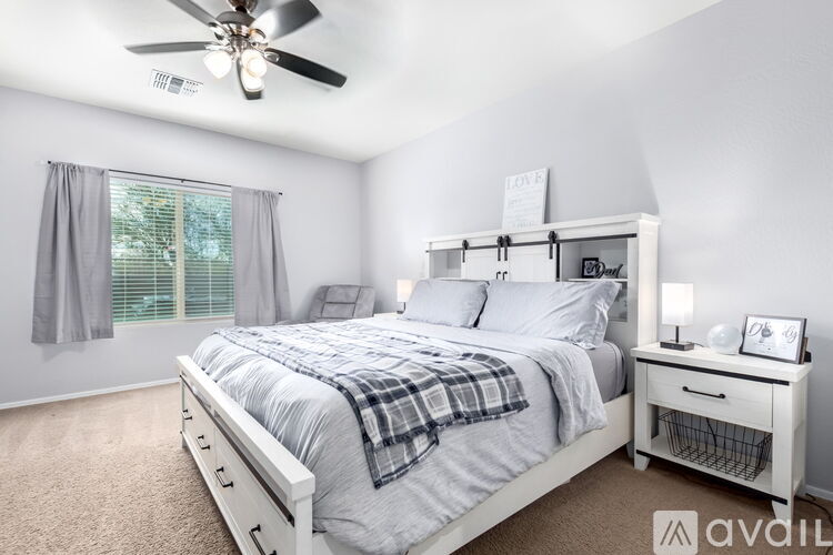 A bedroom with a bed, nightstand, and window.