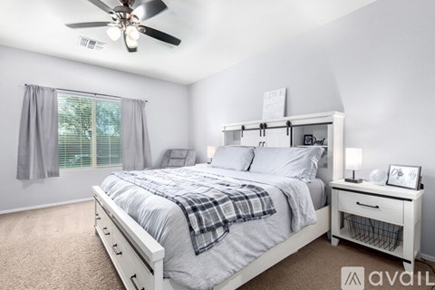 A bedroom with a bed, nightstand, and window.