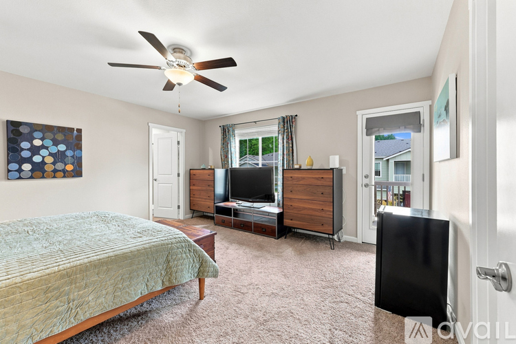 A bedroom with a bed, dresser, and television.