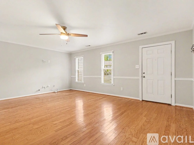 A room with wooden floors and a ceiling fan.
