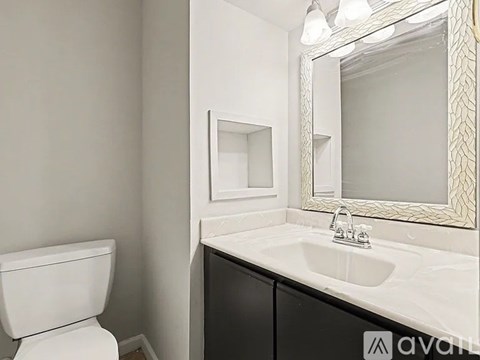 A white toilet sits next to a sink in a bathroom.