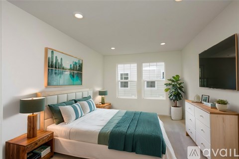 A bedroom with a bed, a nightstand with a lamp, a dresser, a mirror, and a painting on the wall.