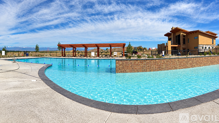 A large swimming pool with a red pergola in the background.