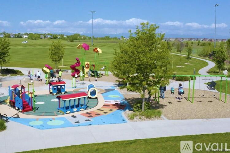 A playground with a blue and white slide and a red and blue train.