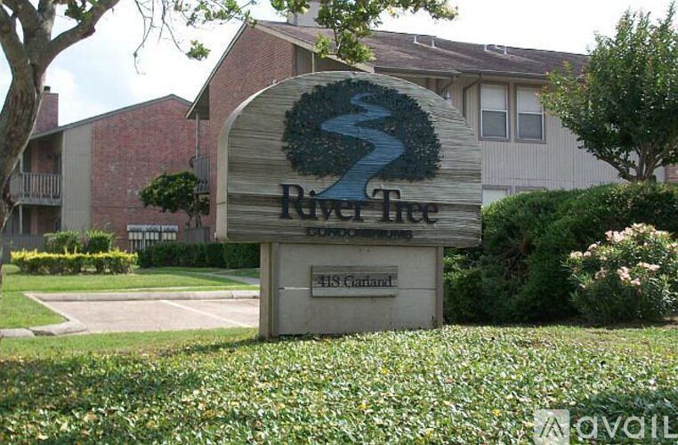 A sign for River Tree Court in front of a building.