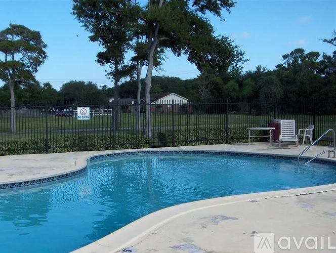 A pool surrounded by a black fence with a sign that says "NO DIVING".