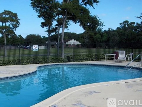 A pool surrounded by a black fence with a sign that says "NO DIVING".