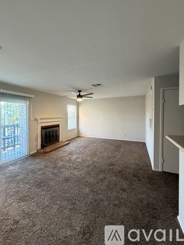 A living room with a fireplace and a ceiling fan.
