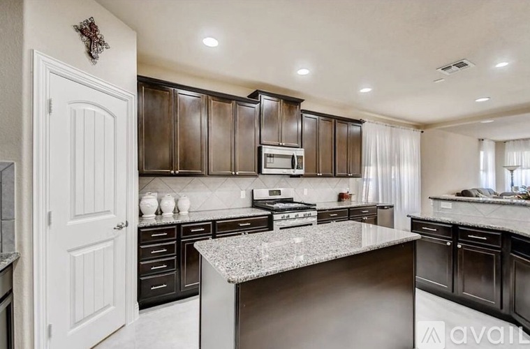 A modern kitchen with dark brown cabinets and a central island.