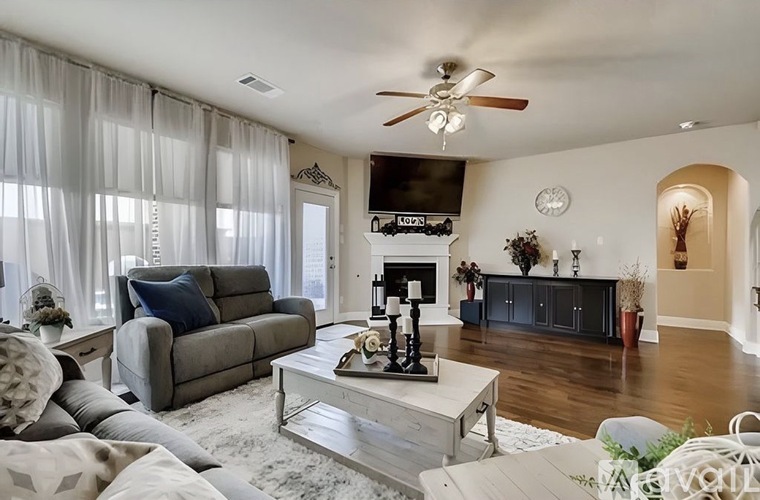 A living room with a grey couch, a white coffee table, and a fireplace.