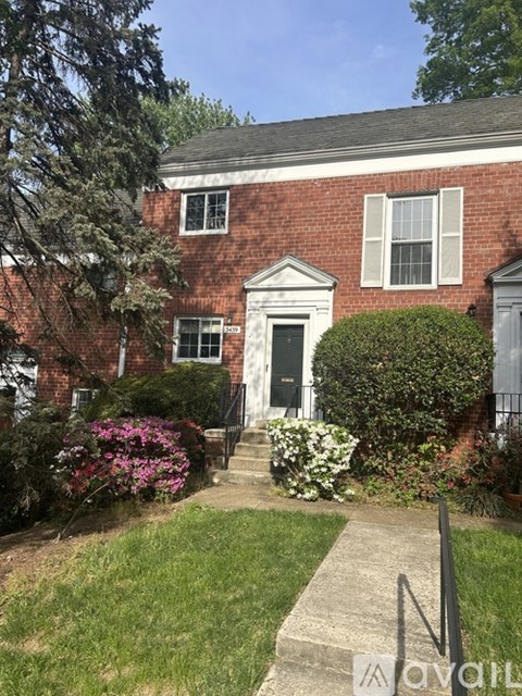 A red brick house with a white door and windows.