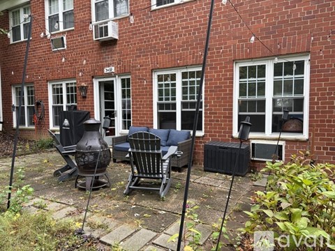 A patio with a table and chairs is in front of a brick building.