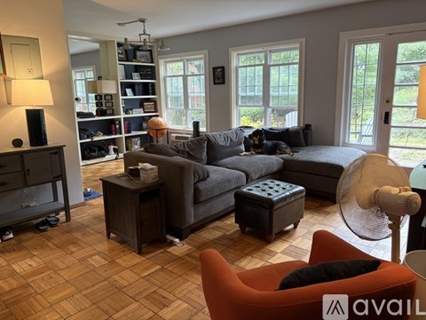 A living room with a grey couch and a red chair.