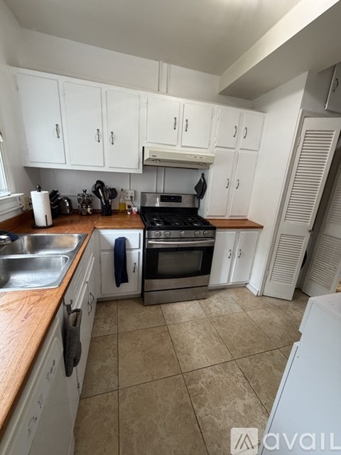 A kitchen with white cabinets and a tiled floor.