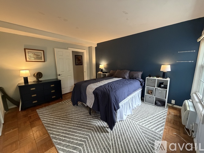 A bedroom with a bed, nightstand, and lamp.