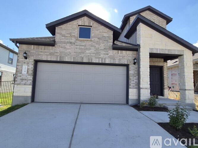 A house with a garage door and a brick facade.