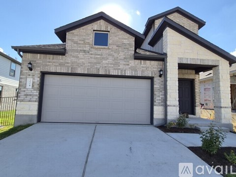 A house with a garage door and a brick facade.
