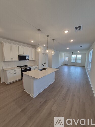 A kitchen with white cabinets and a wooden floor.